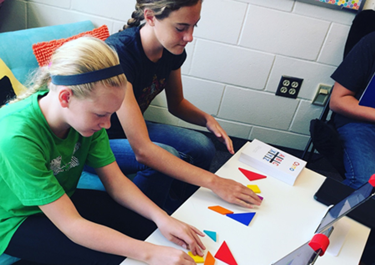 image of students in classroom. Making objects out of geometric shapes.